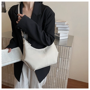 Détail du sac hobo crème avec texture cuir grainé et couture verticale élégante