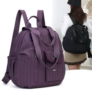 Close-up of deep purple pleated nylon backpack showing multi-pocket design and texture