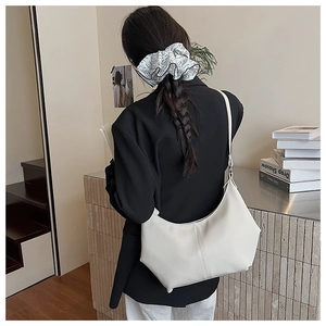 Détail d'un sac à bandoulière demi-lune blanc crème en cuir grainé pour le quotidien