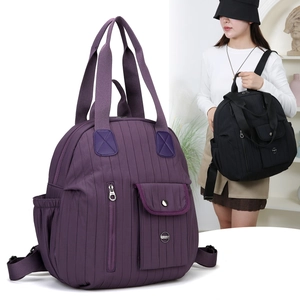 Detail view of purple waterproof nylon backpack featuring vertical quilted patterns and straps