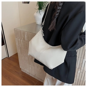 Détail d'un sac demi-lune blanc crème avec texture litchi et finitions argentées