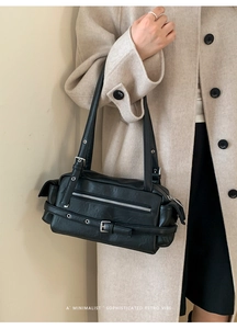 Detail of black retro shoulder bag with silver hardware and vintage leather texture