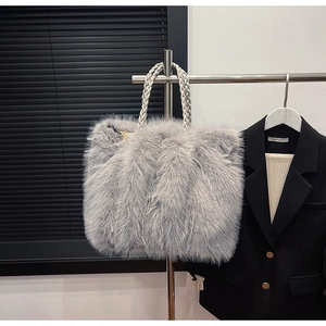 Detailaufnahme der flauschigen grauen Kunstfell-Tasche mit dekorativem Flechtgriff