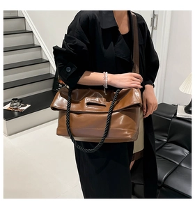 Detailed view of dark brown PU leather tote with unique folding cover and twisted strap