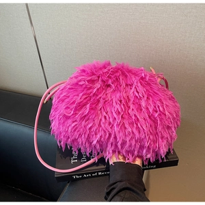 Détail du sac à main en plumes rose vif avec une fine bandoulière en cuir souple