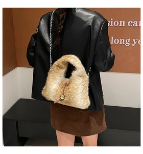 Dettaglio borsa a tracolla in peluche marrone chiaro con sfera dorata e catena d'argento