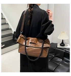 Rear view of model wearing a large brown PU leather tote bag with woven rope handle detail