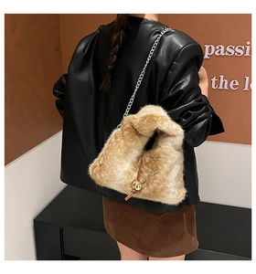 Dettaglio della borsa tote in peluche con catena d'argento e ciondolo a sfera dorata
