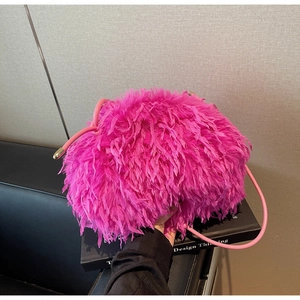 Détail du sac à plumes rose fushia en forme de nuage avec perle dorée sur la bandoulière
