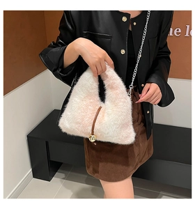 Dettaglio della borsa a tracolla in peluche con cinturino in pelle e sfera dorata