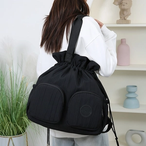 Detailansicht des schwarzen Kordelzug-Rucksacks mit Seitentasche und Nylon-Textur am Model