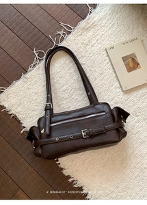 Flat lay of a retro brown faux leather shoulder bag with zipper and belt details