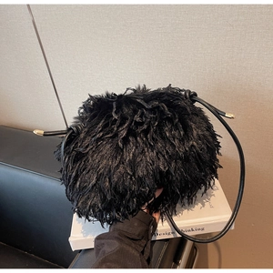 Détail du sac à bandoulière en fausse fourrure noire avec accents métalliques dorés