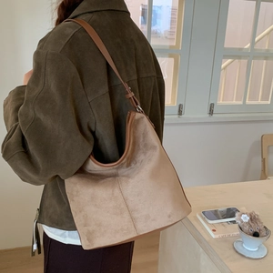 Detail of soft matte leather shoulder bag with adjustable brown strap and silver buckle