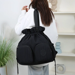 Detailansicht eines schwarzen Kordelzug-Rucksacks mit Doppeltaschen an einem Modell