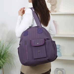 Detail of dark purple large capacity backpack with vertical quilting and multiple pockets