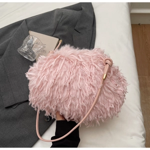 Vue détaillée de la texture en fausse fourrure rose et des accents dorés du sac à bandoulière