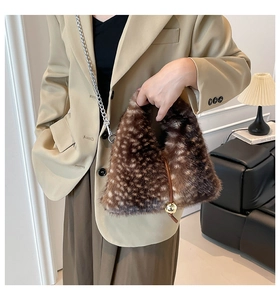 Dettaglio della borsa in peluche con stampa animalier e ciondolo a sfera dorata elegante