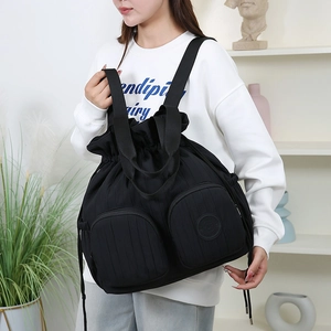 Detail eines schwarzen Rucksacks mit großem Fassungsvermögen, Kordelzug und Reißverschlusstaschen