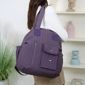 Detail view of purple nylon travel backpack with vertical quilting and multiple pockets