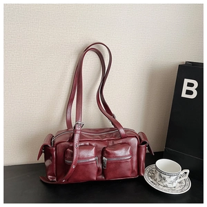 Detailed macro view of dark red vintage motorcycle bag with multiple functional pockets