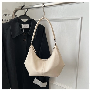 Détail du sac hobo blanc crème montrant le cuir texturé et les finitions argentées