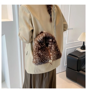 Dettaglio borsa a spalla in peluche animalier con ciondolo dorato e tracolla a catena
