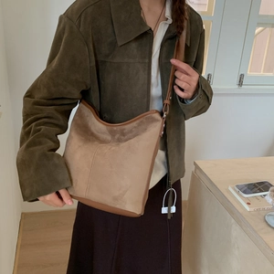 Brown suede hobo bag shown on a model highlighting its vintage matte texture and strap