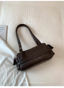 Detail view of the retro dark brown shoulder bag with side pocket and adjustable metal buckle