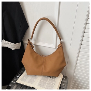 Détail du sac hobo marron caramel avec coutures verticales et finitions en métal argenté