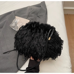 Détail du sac à main en peluche noire montrant la texture douce et les finitions dorées