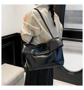 Detail view of large black tote bag with thick twisted rope shoulder strap in PU leather