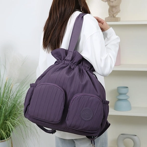 Detailansicht lila Rucksack mit Kordelzug, vertikaler Plissee-Textur und Reißverschlusstaschen