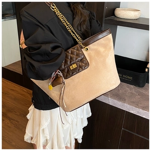 Detail of vintage tote bag with suede texture, chain strap, and quilted flap pocket