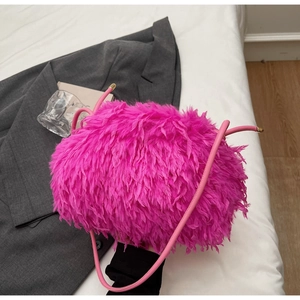 Détail d'un sac rose fuchsia en fausse fourrure avec bandoulière et finitions dorées