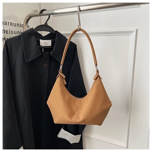 Détail du sac croissant en cuir grainé marron chameau montrant coutures et fermeture