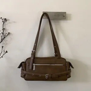 Detail of dark brown retro shoulder bag with metallic zipper and buckle straps