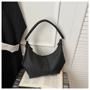 Vue détaillée de la texture en cuir mat noir et des coutures du sac hobo en demi-lune