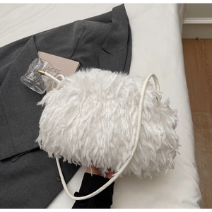 Détail du sac à bandoulière en plumes blanches douces avec accents métalliques dorés