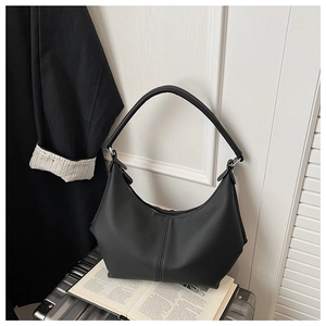 Vue détaillée d'un sac hobo demi-lune en cuir mat noir avec des plis et une bandoulière