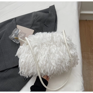Gros plan sur la texture pelucheuse blanche du sac à bandoulière en plumes synthétiques