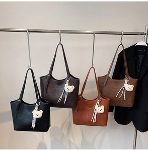 Four large PU leather tote bags in black and brown shades with plush bear charms