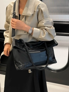 Fashionable black large capacity tote bag with glossy leather and unique twisted handles