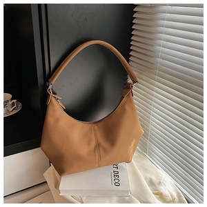 Détails du sac demi-lune en cuir caramel avec texture fine et boucles métalliques