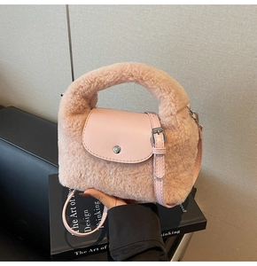Détail d'un sac à main en fausse fourrure rose avec bandoulière et bouton pression