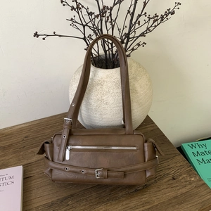 Macro shot of brown retro pillow bag with silver buckle and metallic zipper detail