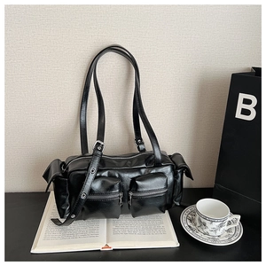 Detailed close-up of a vintage black multi-pocket shoulder bag with glossy leather texture