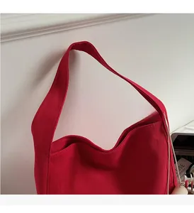 Dettaglio dei manici larghi rinforzati su una borsa tote in tela rossa minimalista