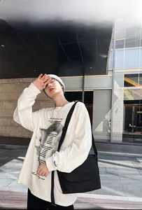 Dettaglio di una t-shirt bianca oversize con stampa artistica e grafiche di lettere