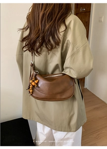 Retro brown half-moon shoulder bag styled on a model with unique wooden bead charms